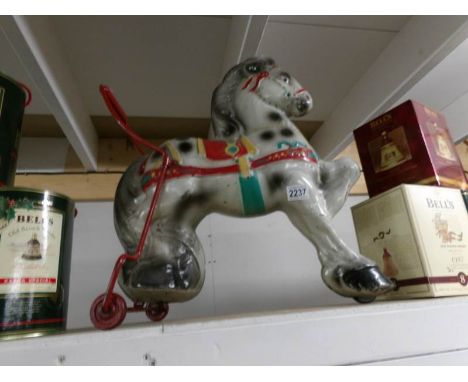 A vintage metal push along toy horse.