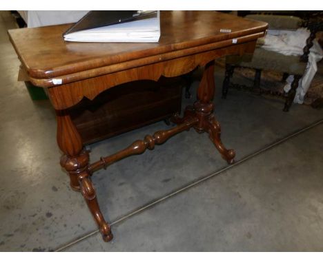 A Victorian mahogany fold over card table (Worm in legs).