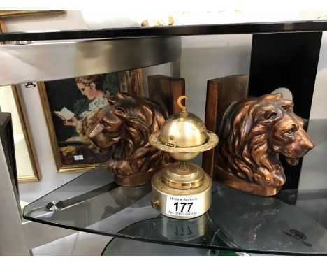 A pair of lion bookend and a globe table lighter