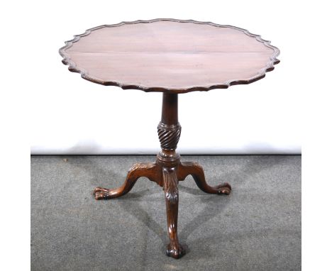 A Georgian mahogany tripod table, tilt-top with shaped and moulded outline, baluster column with spiral twist section, carved