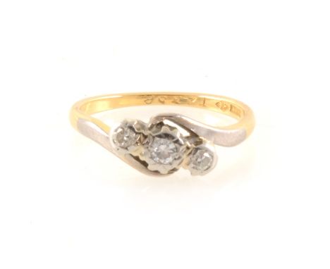 A diamond three stone crossover ring, the brilliant cut stones illusion set in a yellow and white metal mount stamped 18ct, g