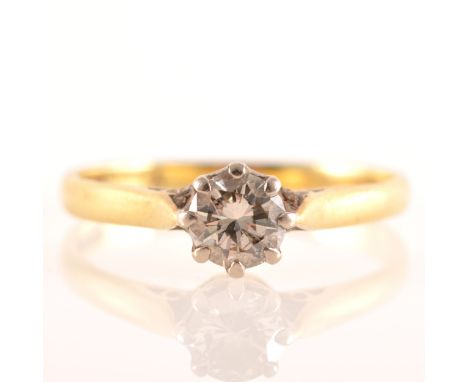 A diamond solitaire ring, the brilliant cut stone claw set in an 18 carat yellow and white gold mount hallmarked Sheffield 19