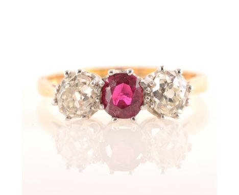 A ruby and diamond three stone ring, an oval faceted ruby 5.3mm x 4.9mm claw set with an old cushion cut diamond claw set to 