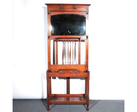 An Edwardian walnut hallstand, with an arrangement of six hooks surrounding an arched bevelled mirror, above a row of spindle