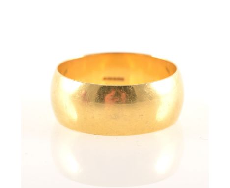 An 18 carat yellow gold wedding band, 9mm wide plain polished D shape, approximate weight 10.8gms, ring size V centre.
