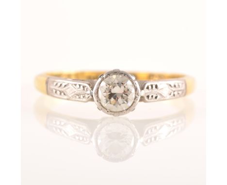 A diamond solitaire ring, the brilliant cut stone illusion set in a yellow and white metal single stone mount, etched white s