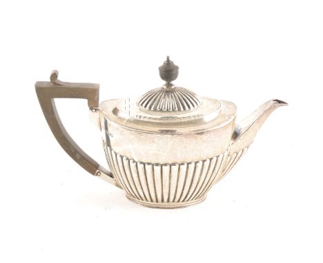 An Edwardian silver teapot, Goldsmiths &amp; Silversmiths Company, London 1902, semi-fluted oval form, wooden handle and fini