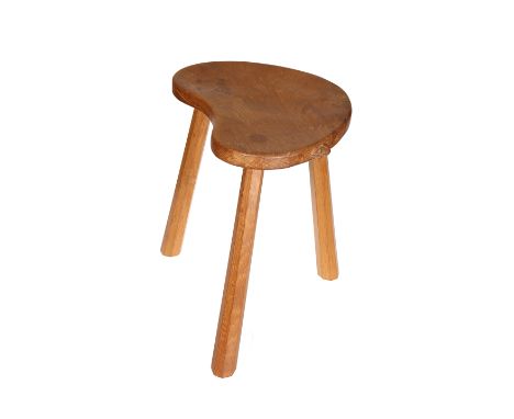 Robert Thompson of Kilburn, a Mouseman oak cow stool, early 1960's, the reniform adzed seat raised on three faceted splayed l