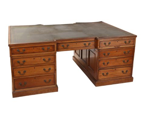 An early 19th Century mahogany partner's desk, the rectangular reeded edge top with inverted breakfront centre and gilt toole