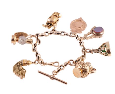 A gold charm bracelet, the heavy interlinked oval links suspending six large charms on articulated links, to include a large 