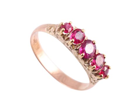 A ruby ring, the five graduating oval mixed cut rubies double claw set in a heavily engraved scroll detail mount between simi