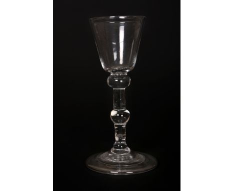 A light baluster wine glass of Newcastle type, c. 1750, with plain round funnel bowl and knopped stem, the domed base with fo