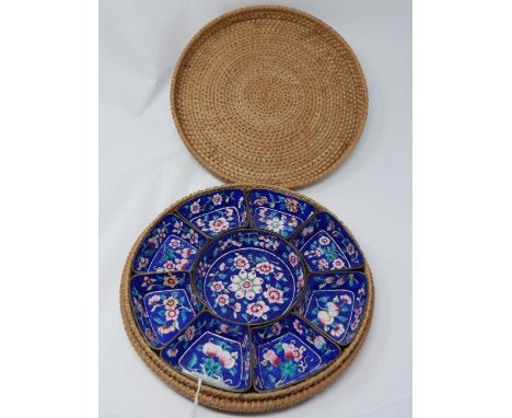 A Chinese sectional set of enamel dishes, comprising a central circular dish flanked by eight dishes, polychrome decorated wi