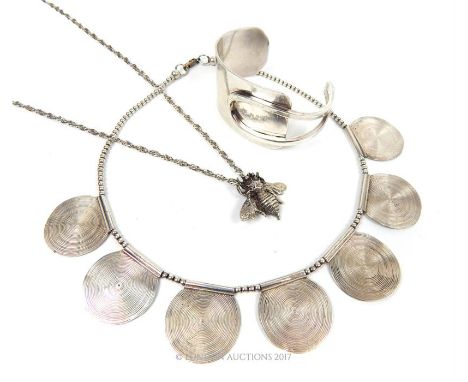 Two silver necklaces, one having a bee pendant, together with a white metal bangle.