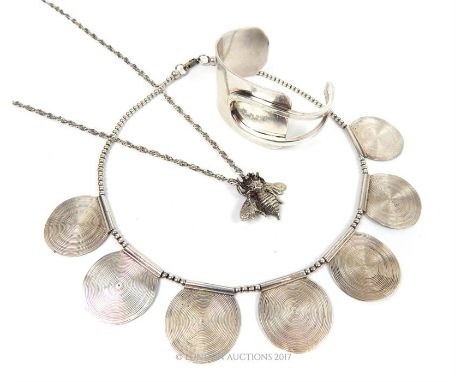 Two silver necklaces, one having a bee pendant, together with a white metal bangle.