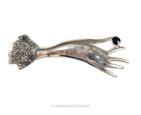 A sterling silver, enamel and marcasite Art Deco-style brooch depicting an elongated ladies hand with a frilled, marcasite-se