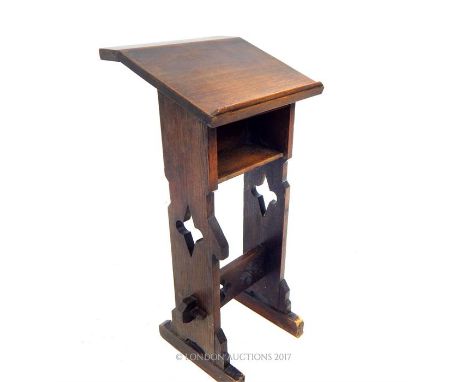 A Gothic-style lecturn/stand with pierced large quatrefoil detailing to the legs, stretcher-supports and a shelf under the le