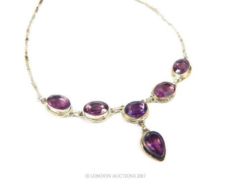 A silver and six faceted amethyst stone necklace.