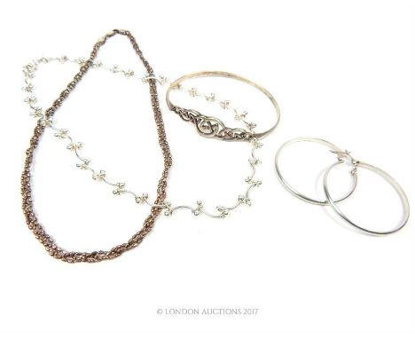 Two silver necklaces, with a bangle and a pair of hoop earrings.