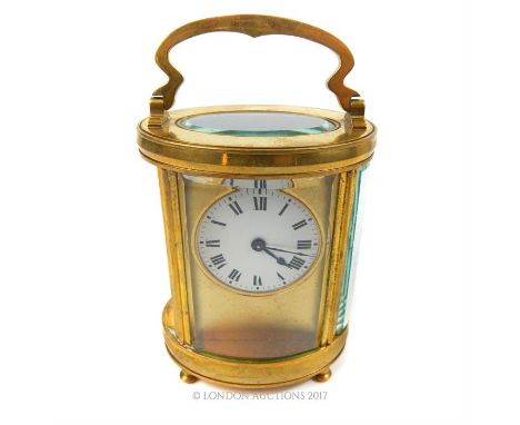 A 20th century gilt brass cylindrical carriage clock, having a circular white dial with Roman numerals, 15 x 9 x 6.5cm.