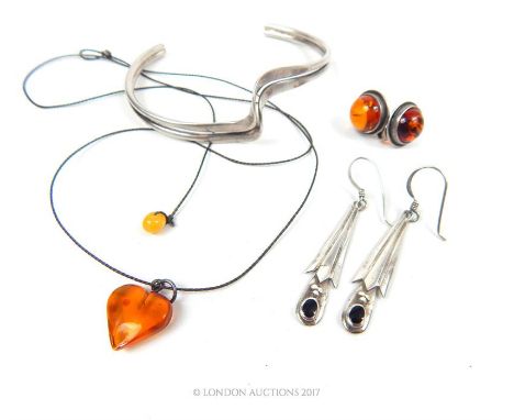 A Baltic amber heart form pendant together with two pairs of silver earrings and a silver bangle.