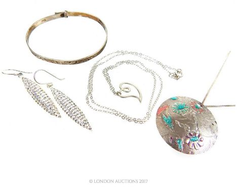 A sterling silver bangle with a pair of silver earrings and a circular pendant on fine chain.