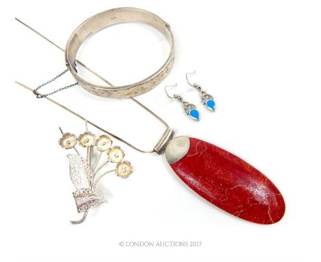 A sponge coral and silver necklace, with a silver bangle and a pair of silver earrings.