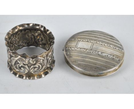 An 833 grade silver circular compact and an embossed silver napkin ring (2). CONDITION REPORT: Napkin ring misshapen to top r