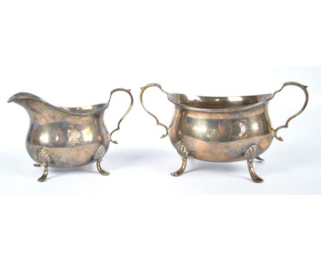 WILLIAM HUTTON & SONS LTD; a George V hallmarked silver twin handled sugar bowl of oval form on four scallop knee outswept su