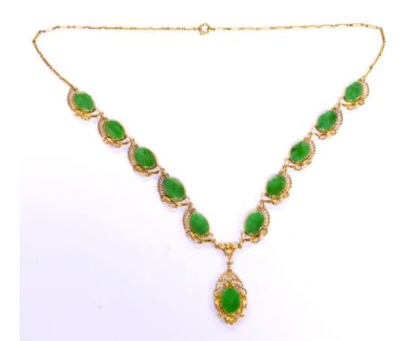 A yellow metal and jade necklace with central oval plaque within a pierced frame beneath ten further oval plaques in shaped p