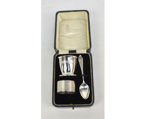 A cased George V hallmarked silver three piece christening set comprising an egg cup, a spoon, Williamson Base & Sons, Birmin