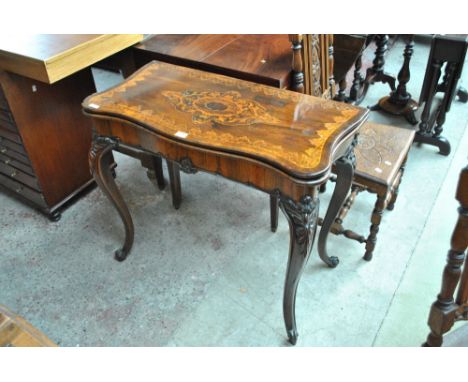 A 19th century rosewood and inlaid serpentine outlined tea table with inlaid hinged top above shaped frieze and knee carved c