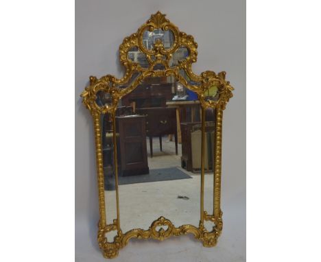 An ornate gilt mirror, 130.5 x 77cm.