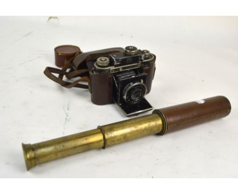 An early 20th century Britannic lacquered brass and leather shafted two drawer telescope, length 35cm when extended, and a Ge