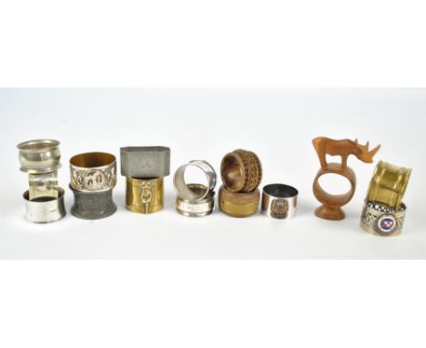 A collection of various napkin rings including two brass examples, a pewter Stuttgart commemorative example, a carved olive w