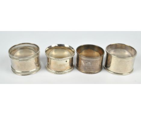 Four variously hallmarked silver circular napkin rings to include a cast rope twist decorated example, Walker & Hall, 1908, a