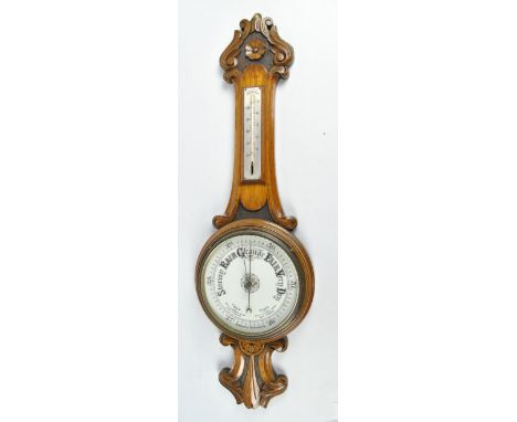 A 1920s carved oak banjo aneroid barometer/thermometer with foliate scroll motifs, height 83cm. CONDITION REPORT: The thermom