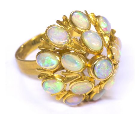 A 14ct yellow gold opal ring in elaborate raised mount and set with central circular opal within an border of 14 oval opals, 