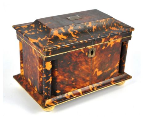 A 19th century tortoiseshell tea caddy with a hinged sarcophagus lid and cylindrical columns to each corner on turned bun fee