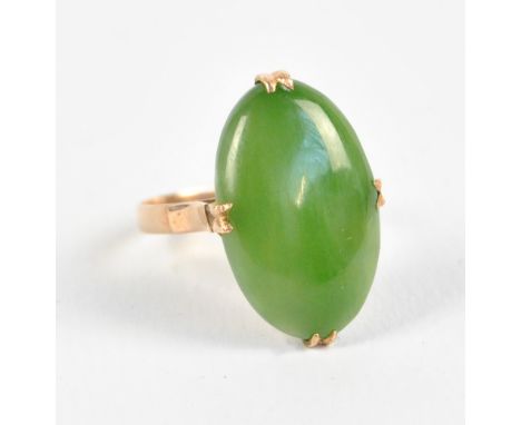 An 18ct yellow gold ring with spinach green oval jadeite plaque in claw setting, size M, approx 3.8g.