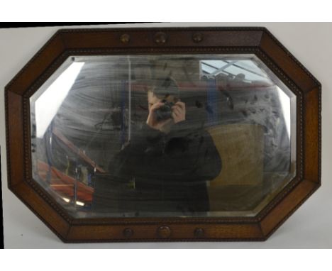 A 1930s oak bead decorated wall mirror of rectangular form with canted corners, 53 x 70cm.
