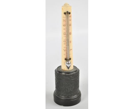 A late 19th century ivory mercury thermometer of plain tapering form, on carved black slate cylindrical base, height 24.5cm. 