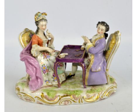 A 19th century German porcelain figure group of a lady and gentleman playing cards on shaped naturalistic foliate scroll gilt