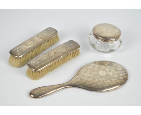 WILLIAM NEALE & SON LTD; a George V hallmarked silver backed three piece dressing table set comprising an oval hand mirror, l