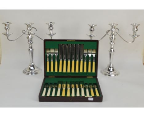A pair of electroplated candelabra with entwined branches above knopped and tapering stem on spreading circular base, span 35