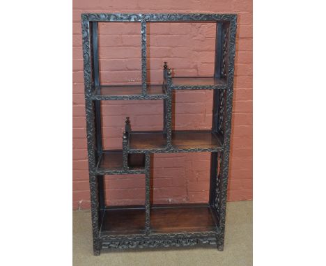 A late 19th century Chinese hardwood étagère with stepped platforms and ornate scroll fret carved and pierced sides, 136 x 77