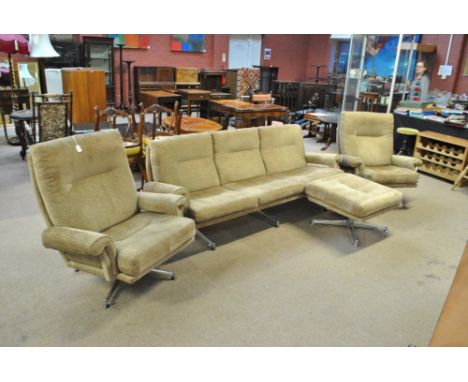 A 1960s/70s upholstered four piece lounge suite comprising a three seat sofa, pair of armchairs and stool, each piece raised 