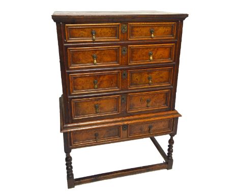 An 18th century oak and burr oak four drawer chest, with original split pin drops, on single drawer stand on bobbin turned st