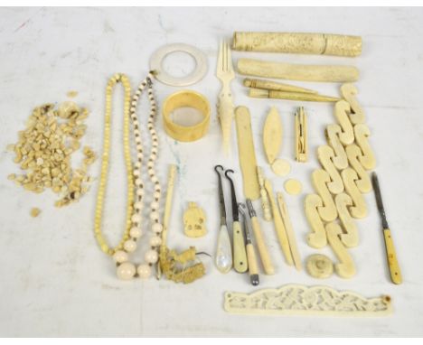 A quantity of bone and faux ivory items including handles, spatula, needle holder, fold out manicure set, beads, etc, and an 