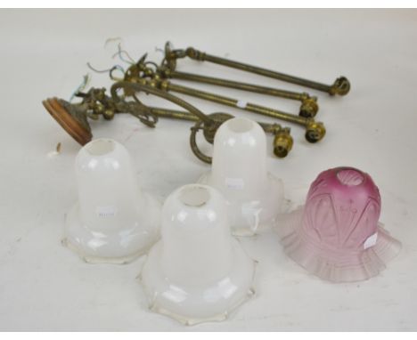 A set of four early 20th century brass tubular swivelling light fittings, length 38cm, with three opaque glass tulip shaped s